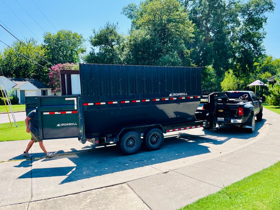 Country Cousins crew loading a full Country Cousins trailer for a junk removal job